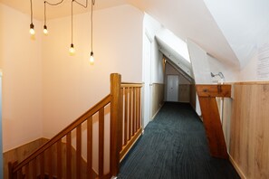 A wooden staircase with a carpeted floor leading to a door at the end. - Hotel le Lion d'or (Lamballe-Armor)