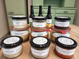 Diversos frascos de comida con etiquetas sobre una superficie de madera.