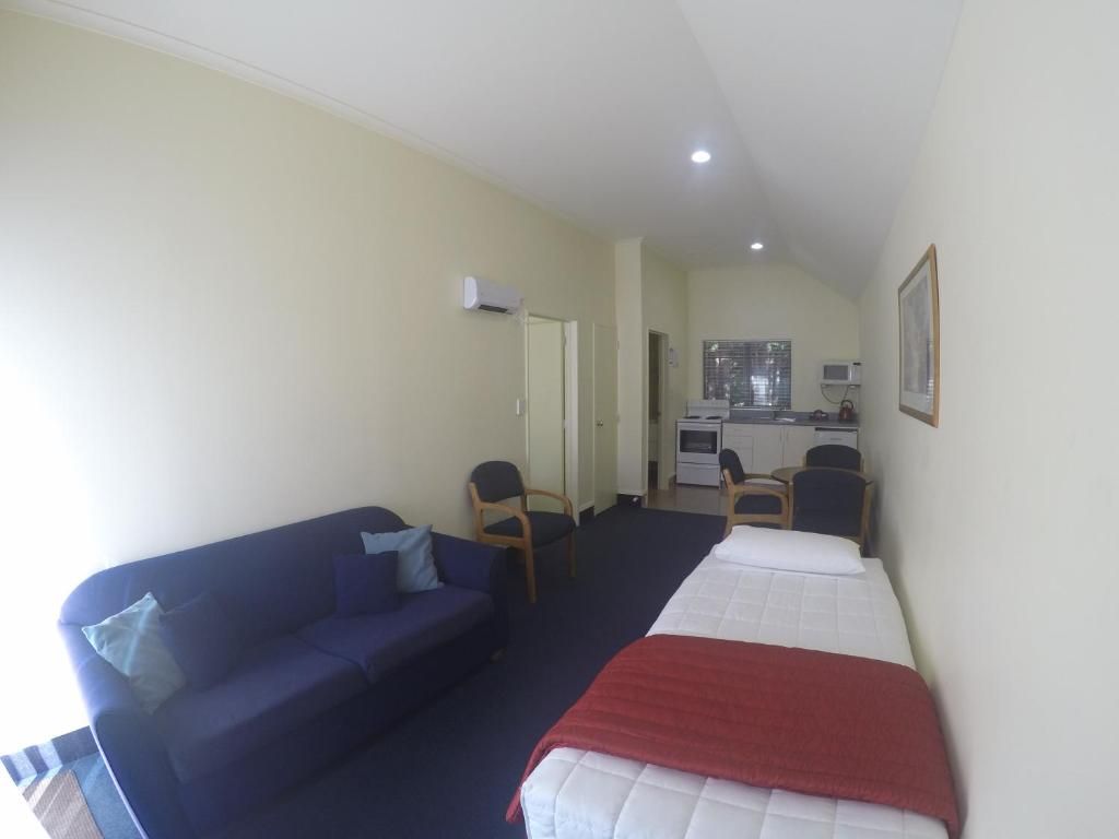 Une chambre d’hôtel comprenant un lit, un canapé, un bureau et une kitchenette.