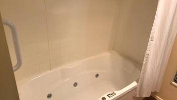 A bathroom with a white bathtub, a shower curtain, and a towel rack.