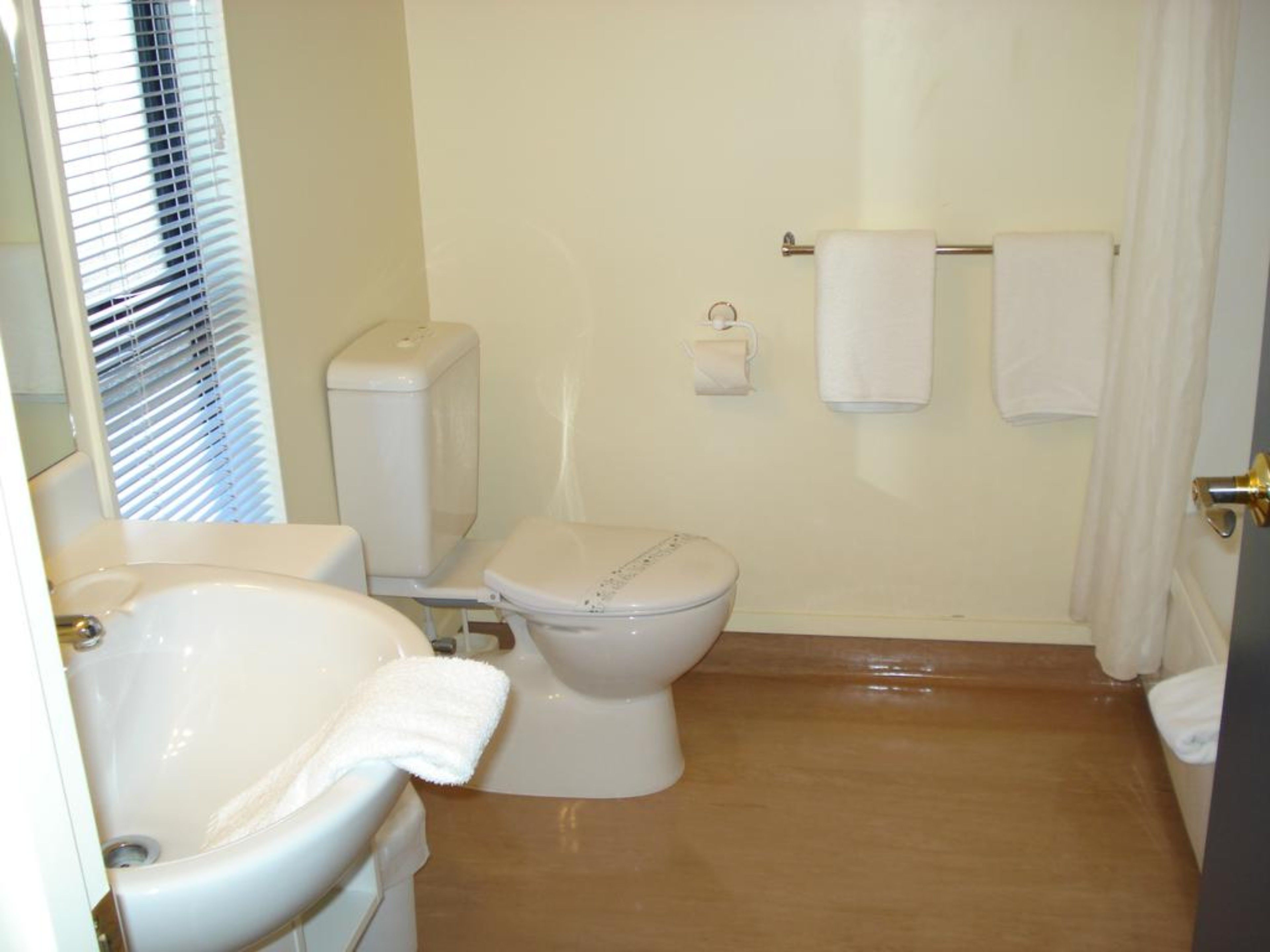 A bathroom with a toilet, sink, and bathtub.