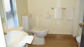 A bathroom with a toilet, sink, and bathtub.