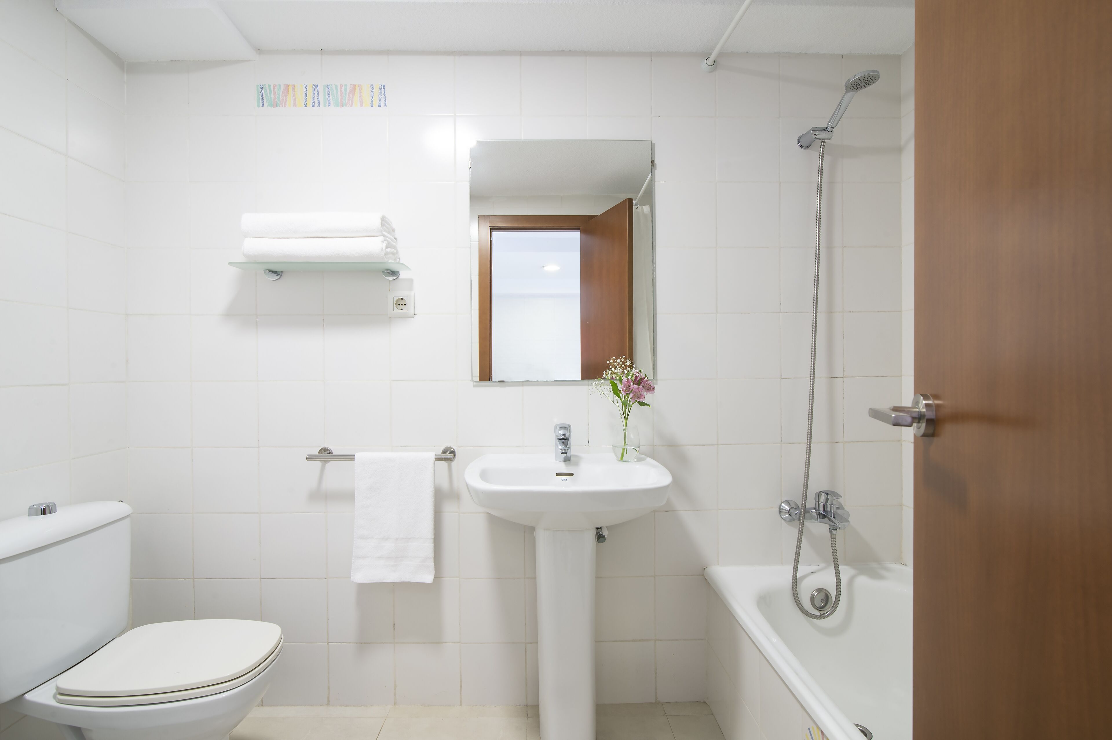 A bathroom with a toilet, sink, and shower.