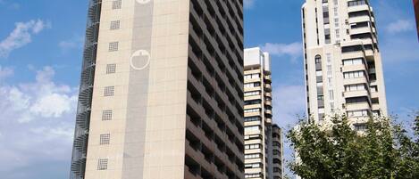 A tall building with a modern design, featuring a prominent circular logo on its facade.