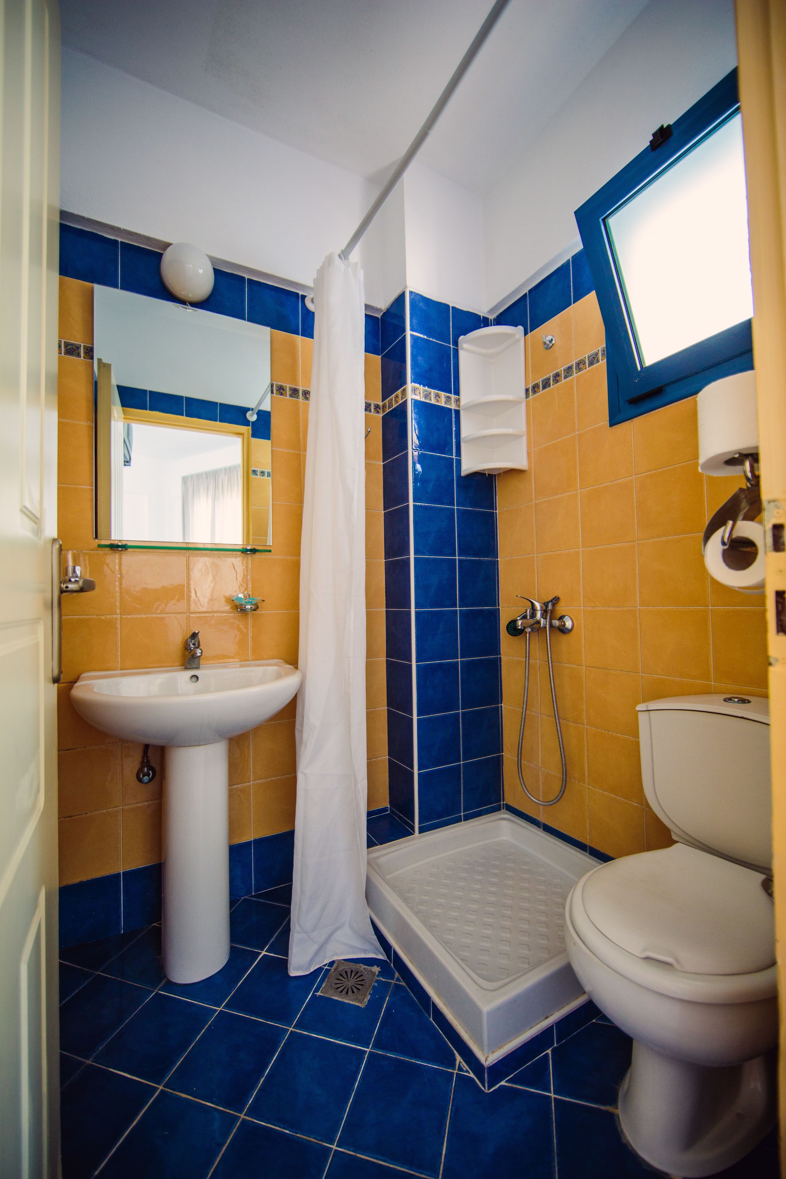 A bathroom with a white sink, a shower, and a toilet.