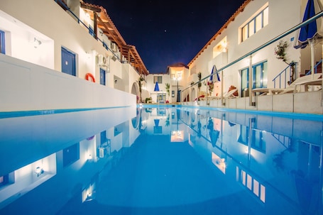 Una piscina al aire libre de temporada, sombrillas