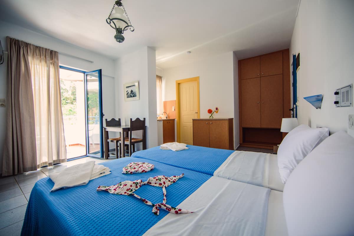 Quarto de hotel com cama, escrivaninha e cadeira.