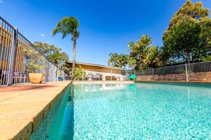 Una piscina al aire libre, sillones reclinables de piscina