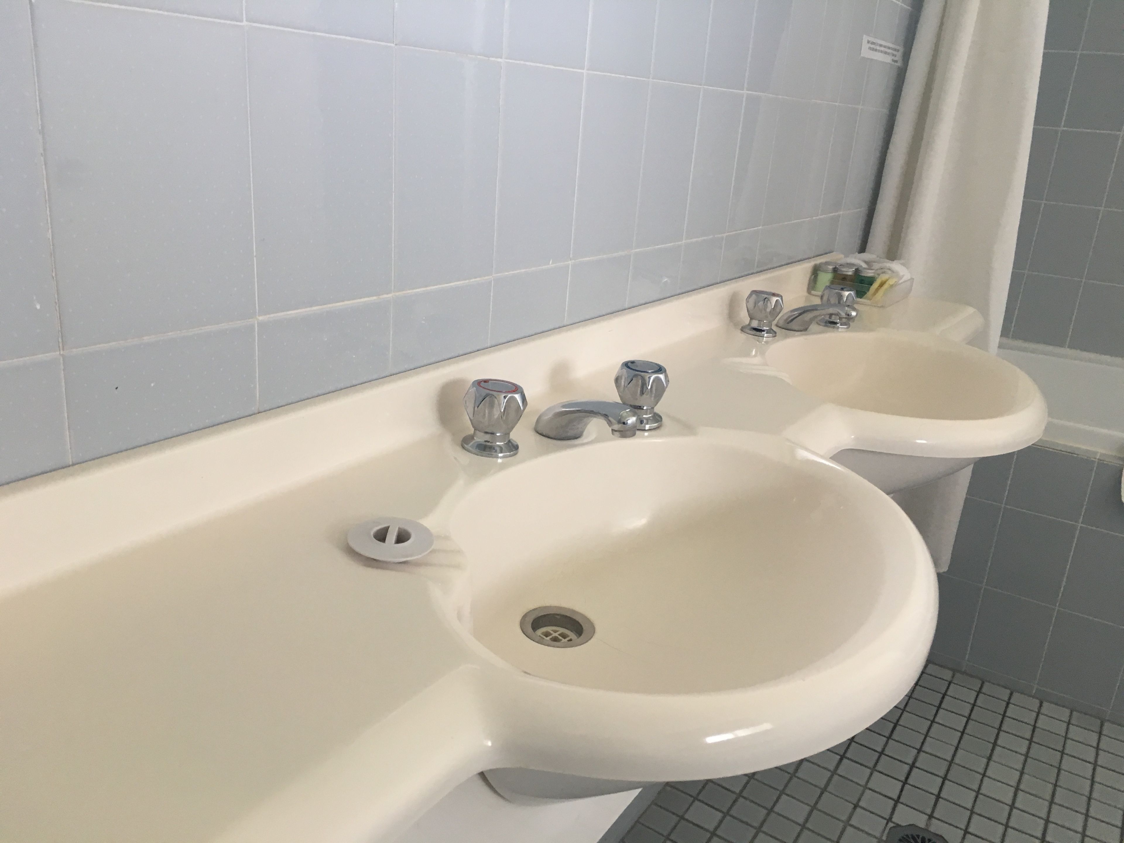 Une salle de bain avec deux lavabos et un miroir.