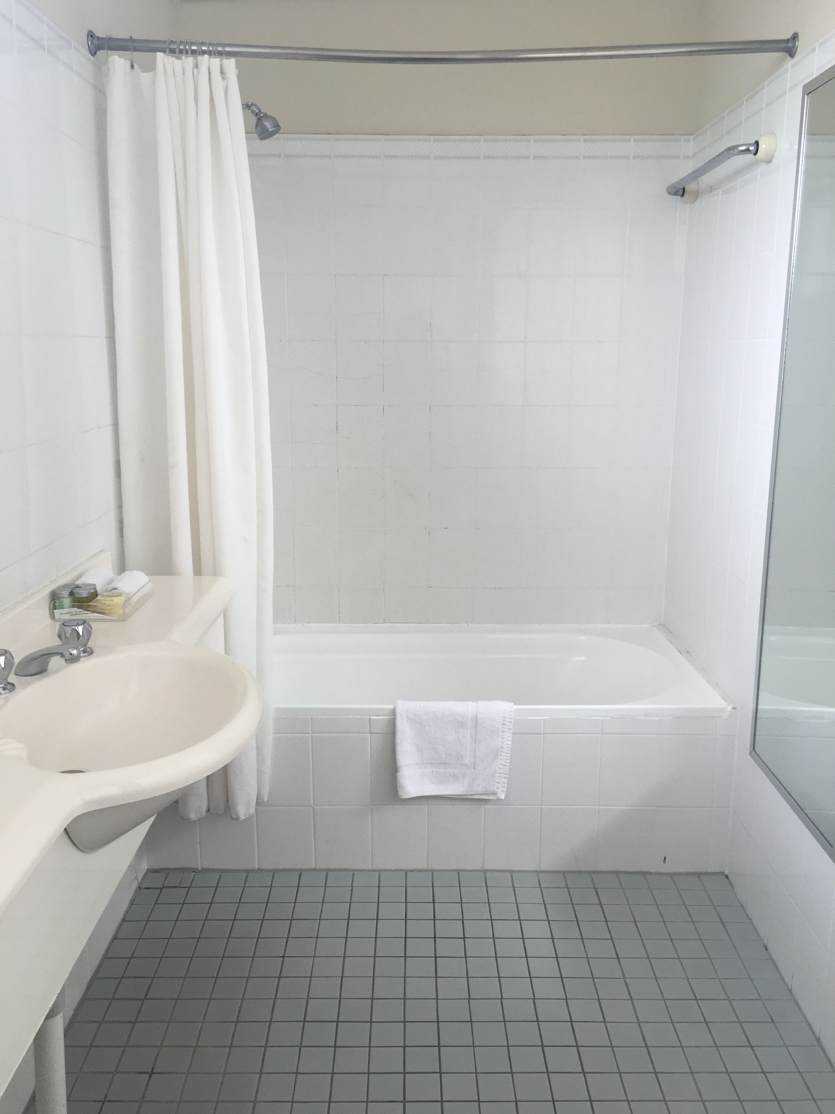 Un baño con bañera, lavamanos y cortina de ducha.