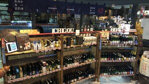 A liquor store with shelves stocked with various bottles and a sign that reads "ICHIGOU". - Capsule Inn Kamata (Tokyo)