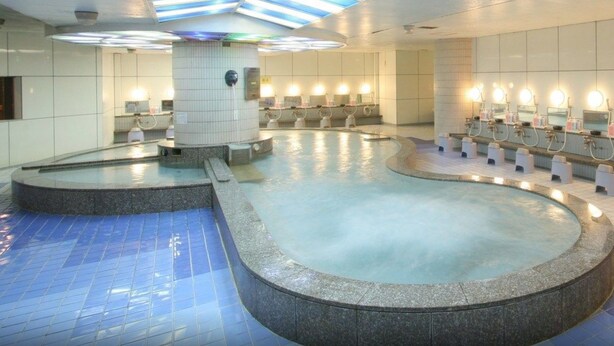 A public restroom with multiple sinks, a central pool, and a skylight. - Capsule Inn Kamata (Tokyo)