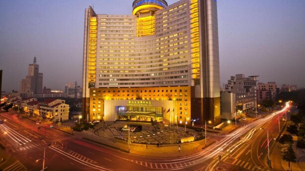 Un grand hôtel doté d’une cour intérieure, de plusieurs étages et d’un élément circulaire distinctif sur le toit.