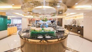 Un espace buffet avec un îlot central, entouré de tables et de chaises, dans un espace intérieur bien éclairé.