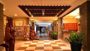 A hotel lobby with a checkered floor, a reception desk, and a statue of a king. - Taman Rosani Hotel (Keroboken Kelod)