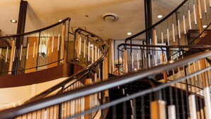Un intérieur moderne avec un escalier à volutes, des rampes en métal et un éclairage encastré.
