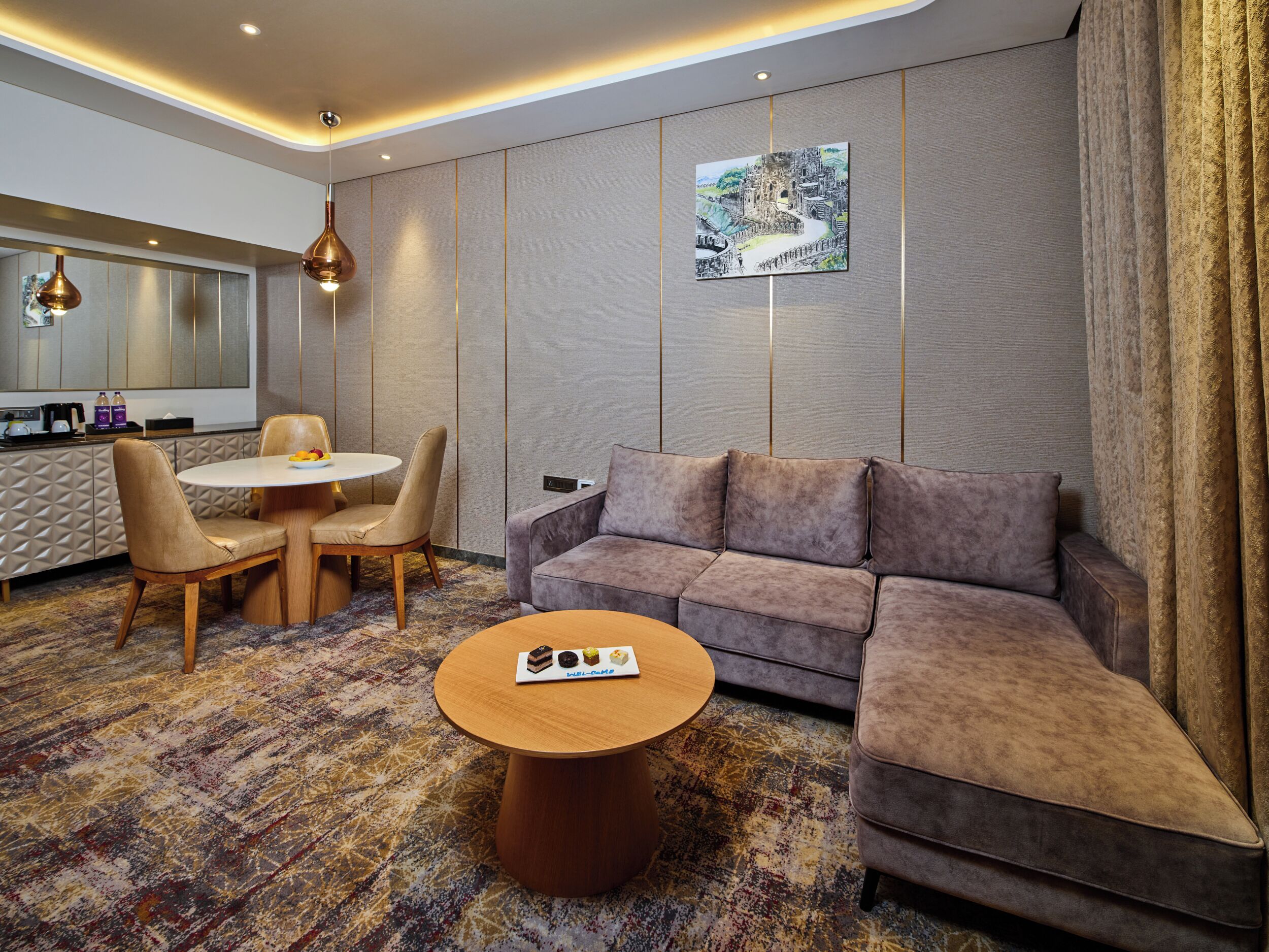 Een moderne hotelkamer met een zithoek, een bank en een bijzettafeltje.