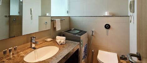 A modern bathroom with a large mirror, a sink, a toilet, and a shower.