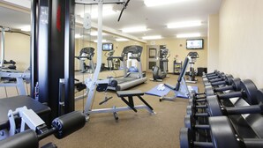 A gym with exercise equipment, a treadmill, and a mirror.