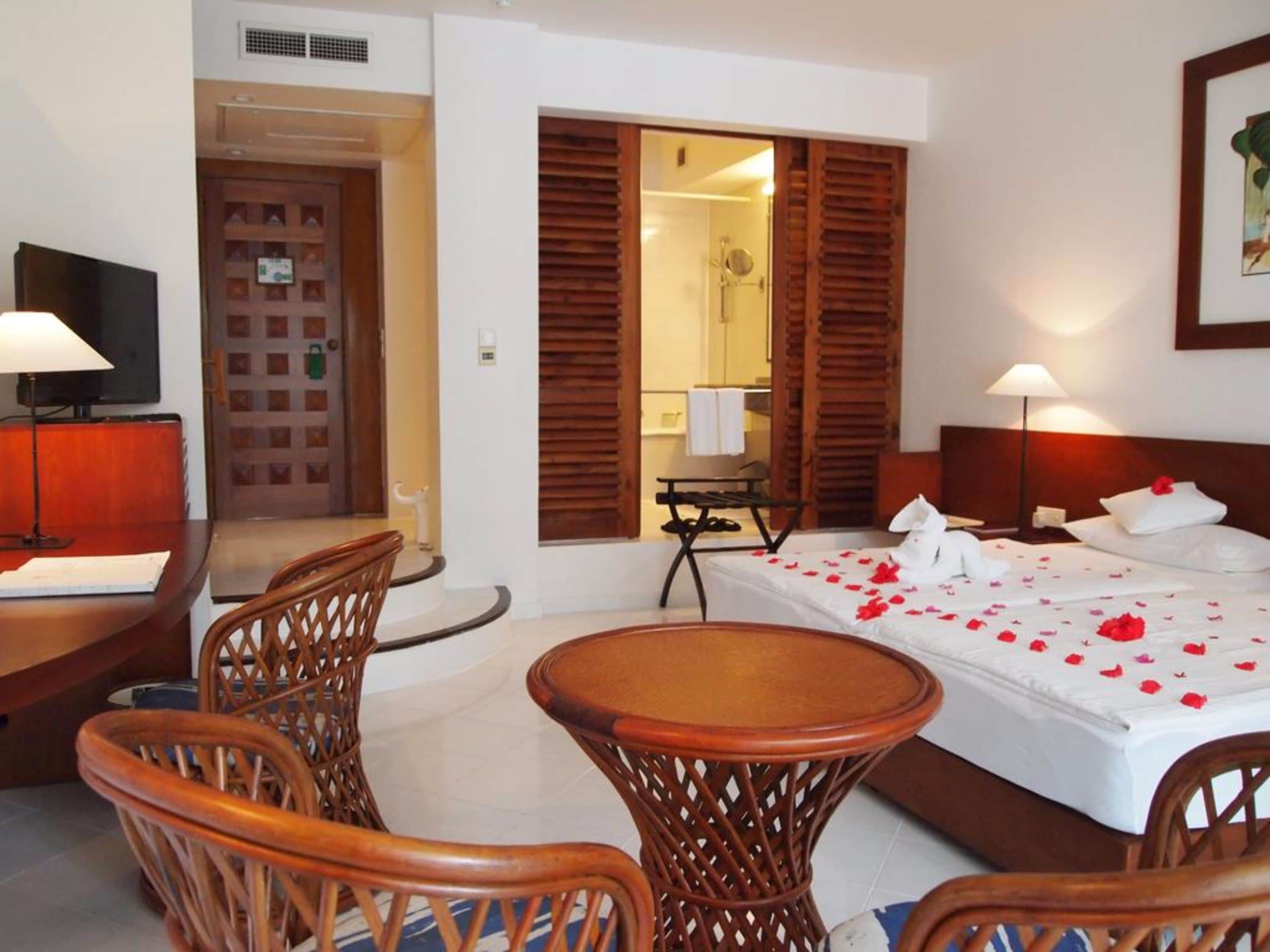 Ein Hotelzimmer mit Bett, Schreibtisch, Stuhl und Fernseher.