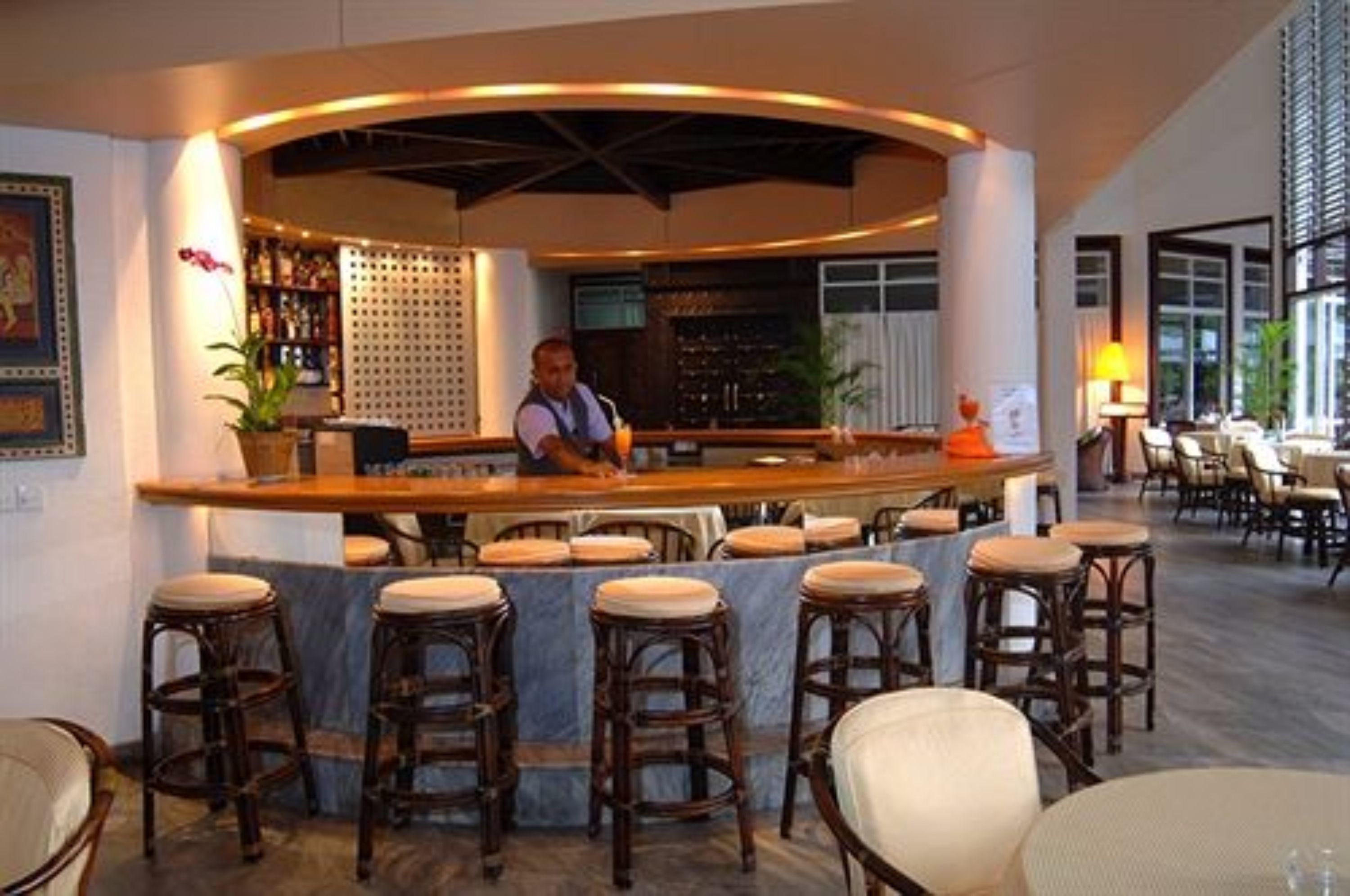A bar area with stools and a bartender.