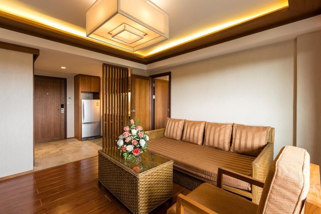 A modern living room with a sofa, a coffee table with a floral centerpiece, and a wooden cabinet.