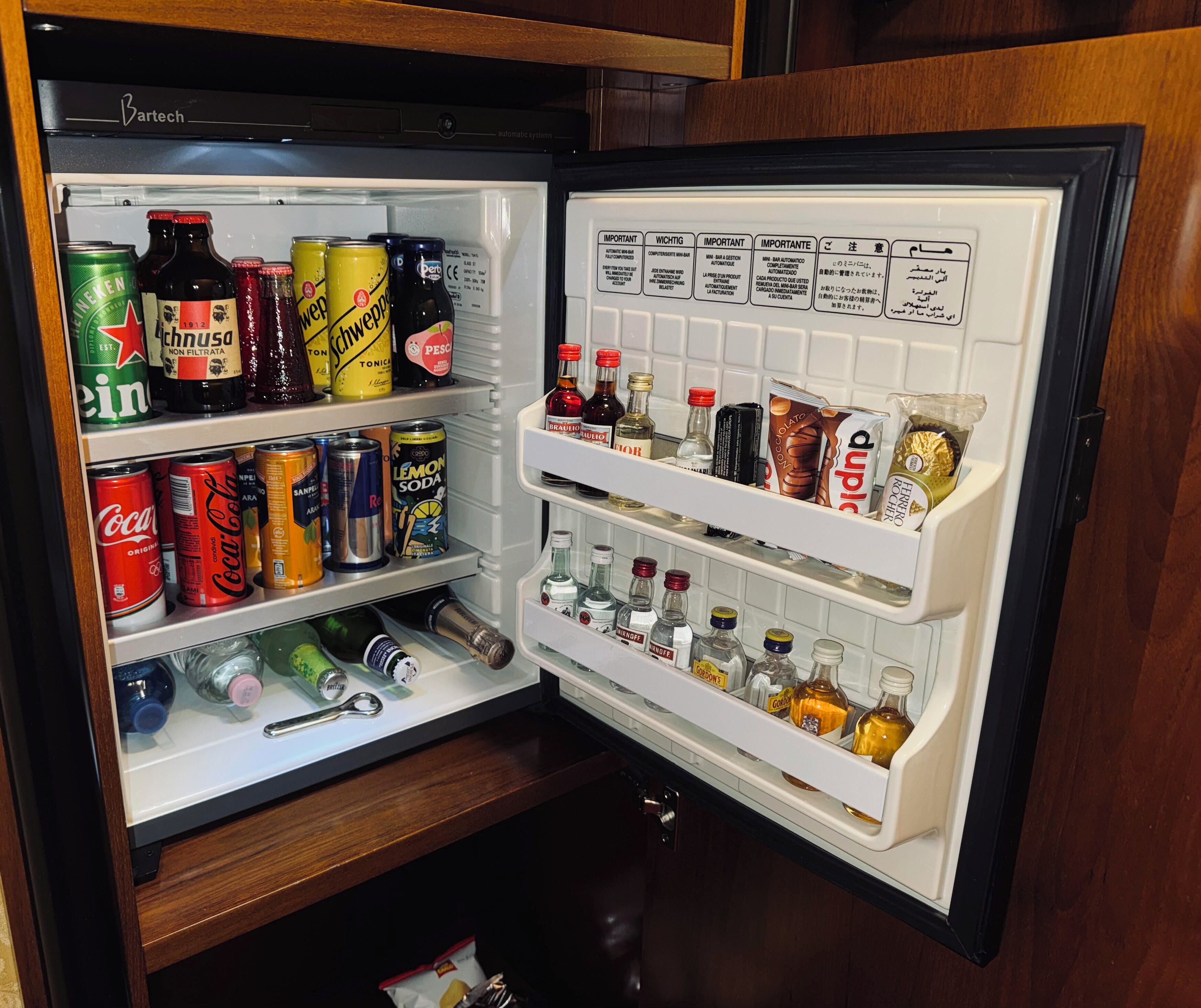 Un réfrigérateur rempli de diverses boissons et d’assaisonnements.