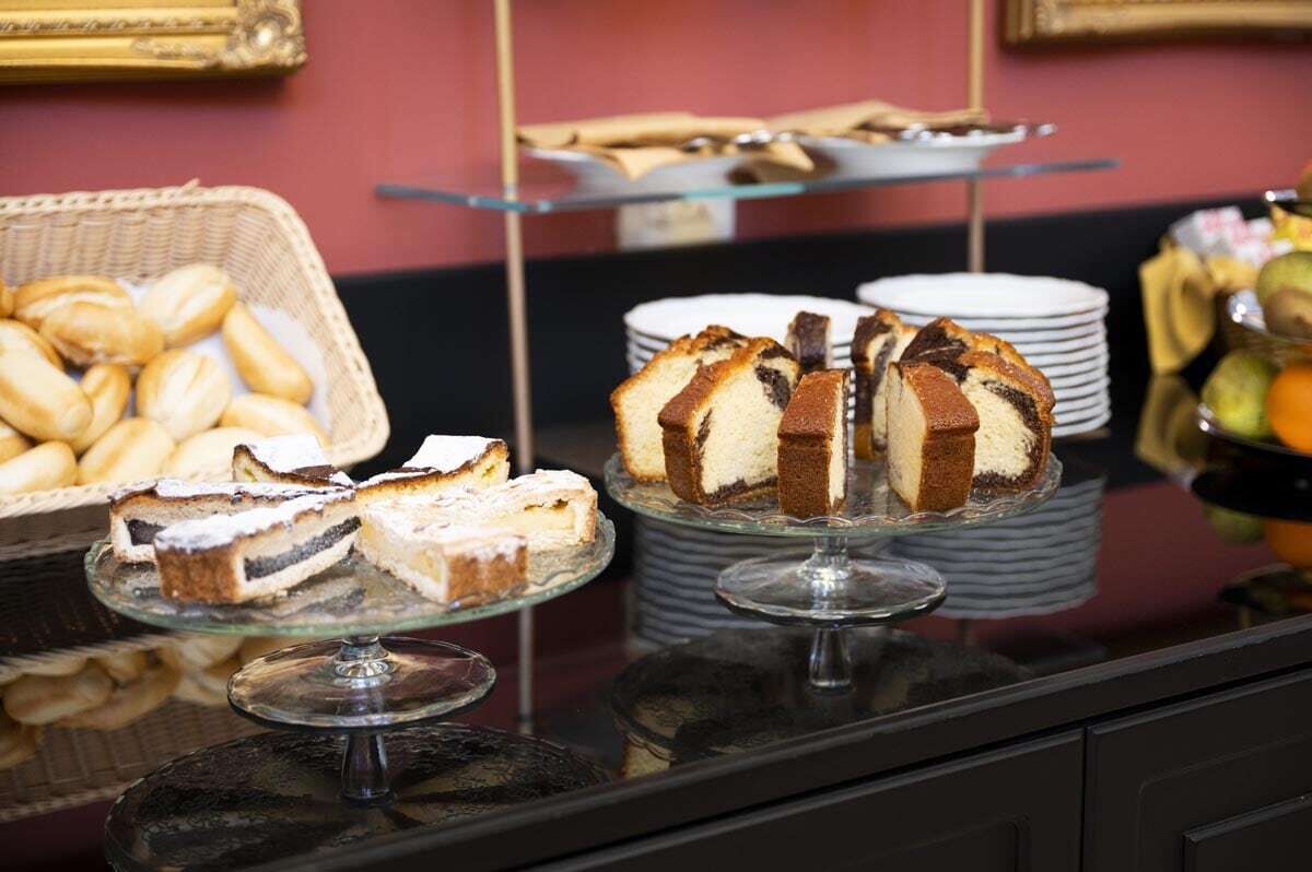 Un bufé con diversos postres, incluyendo pasteles y productos de repostería.