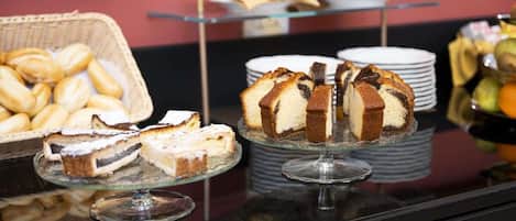 Un bufé con diversos postres, incluyendo pasteles y productos de repostería.