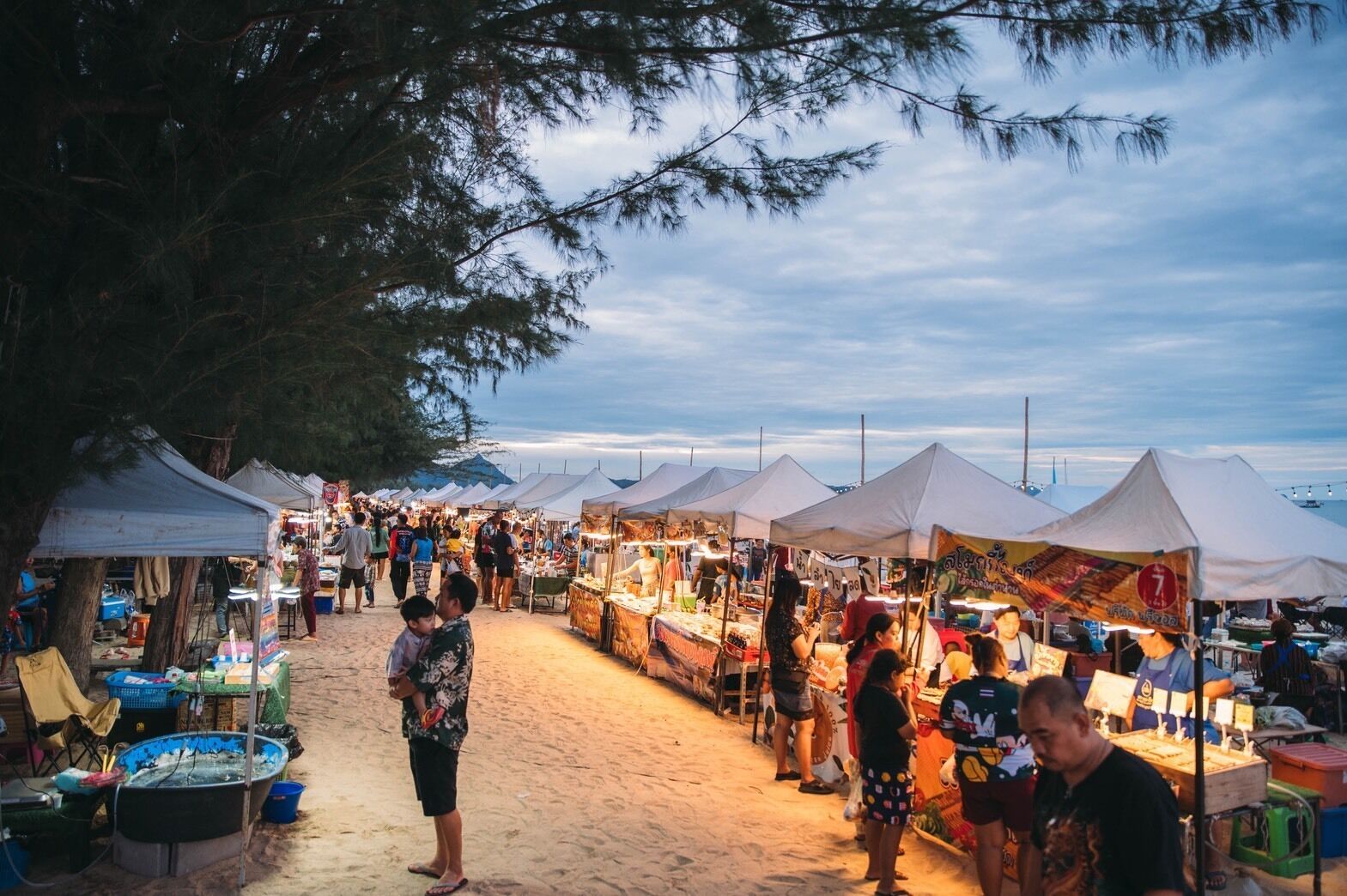 Un mercado al aire libre concurrido, con carpas y puestos de venta.