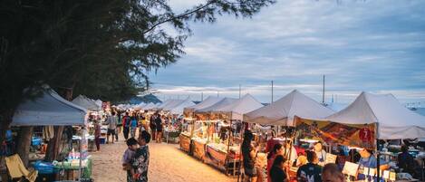 Un mercado al aire libre concurrido, con carpas y puestos de venta.