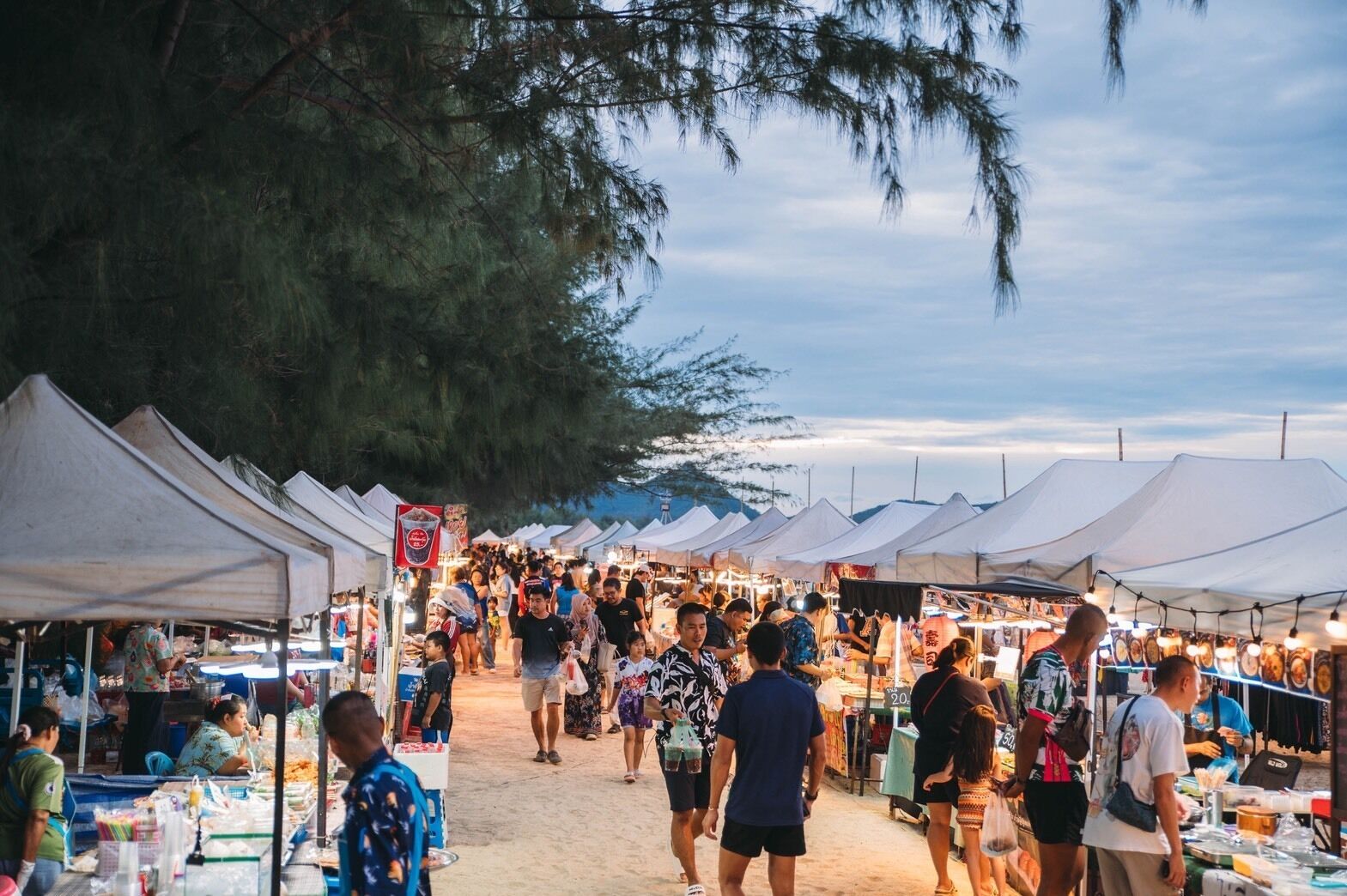 Un mercado al aire libre animado con numerosas tiendas y vendedores.
