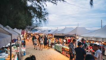 Un mercado al aire libre concurrido, con puestos y gente mirando.