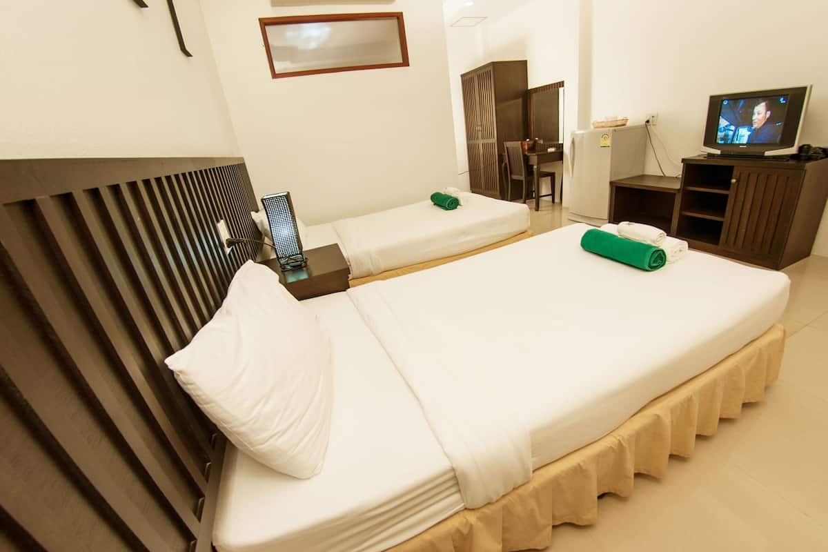A hotel room with two beds, a TV, a desk, and a mirror.