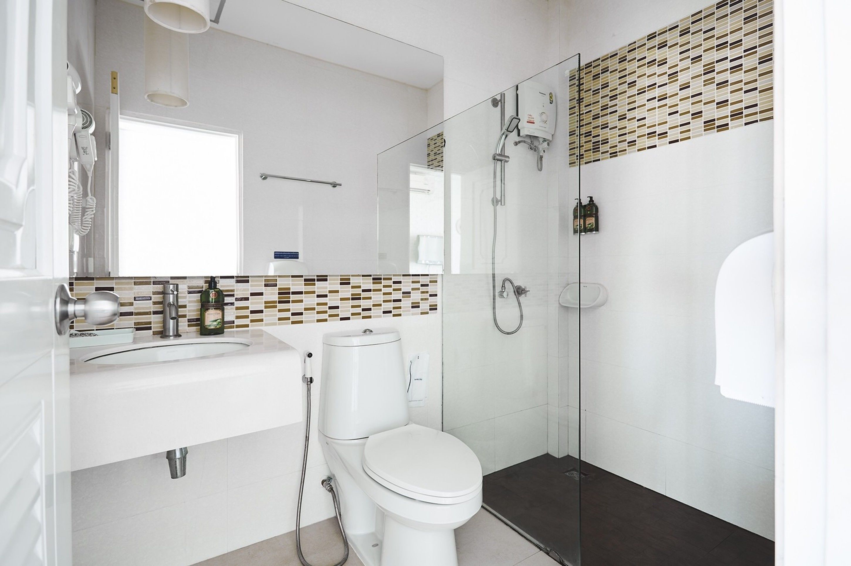 A modern bathroom with a white sink, toilet, and glass-enclosed shower.