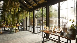 A greenhouse with large windows, wooden tables, and various potted plants. - SiamBeach Resort (Cha-am)