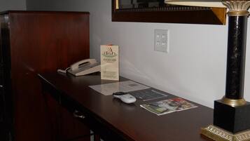 A hotel reception desk with a telephone, a lamp, a menu, and a magazine.