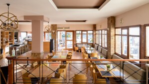A restaurant with a bar area, seating arrangements, and large windows. - Chios Xenia Studio & Apartments (Chios)