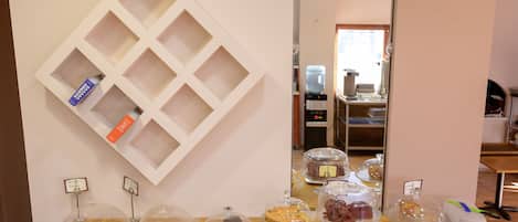 Una mesa de buffet con diferentes alimentos y un dispensador de agua.