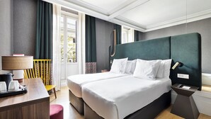 A hotel room with a large bed, bedside tables, a desk with a lamp, and a view of the outside. - One Shot Recoletos (Madrid)