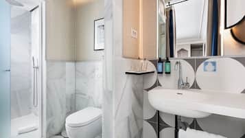 Un baño moderno con ducha, inodoro y lavamanos.