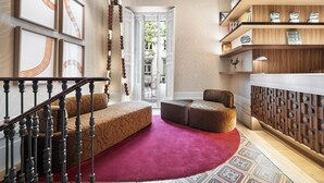 A modern interior with a staircase, a red carpet, and a wooden bookshelf. - One Shot Recoletos (Madrid)
