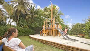 Une aire de jeux avec un toboggan et une structure en bois.