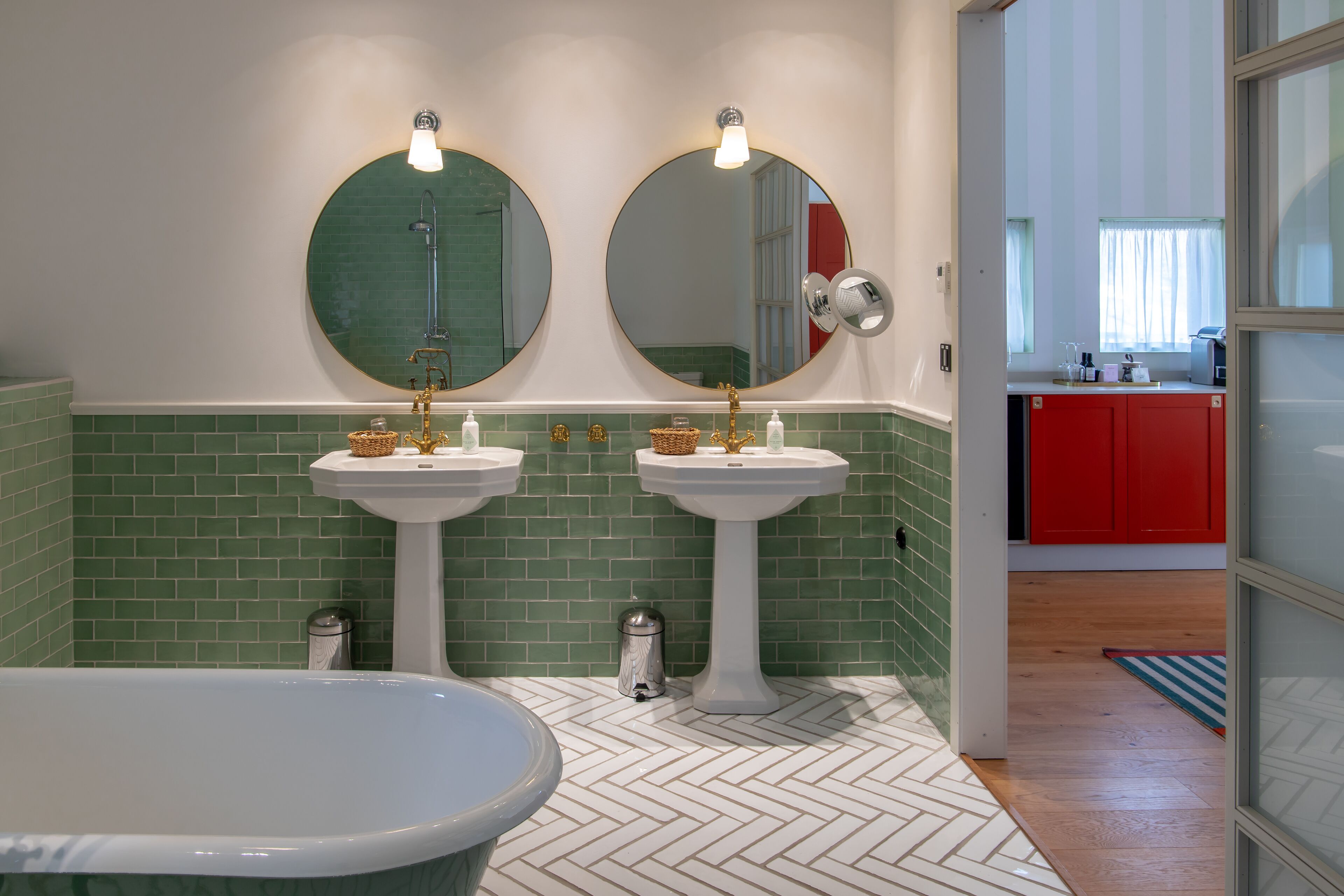 A bathroom with two sinks, a bathtub, and a mirror.