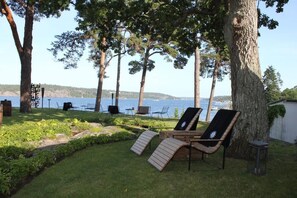 A serene outdoor seating area with lounge chairs and a view of a lake. - Vår Gård Saltsjöbaden (Saltsjobaden)