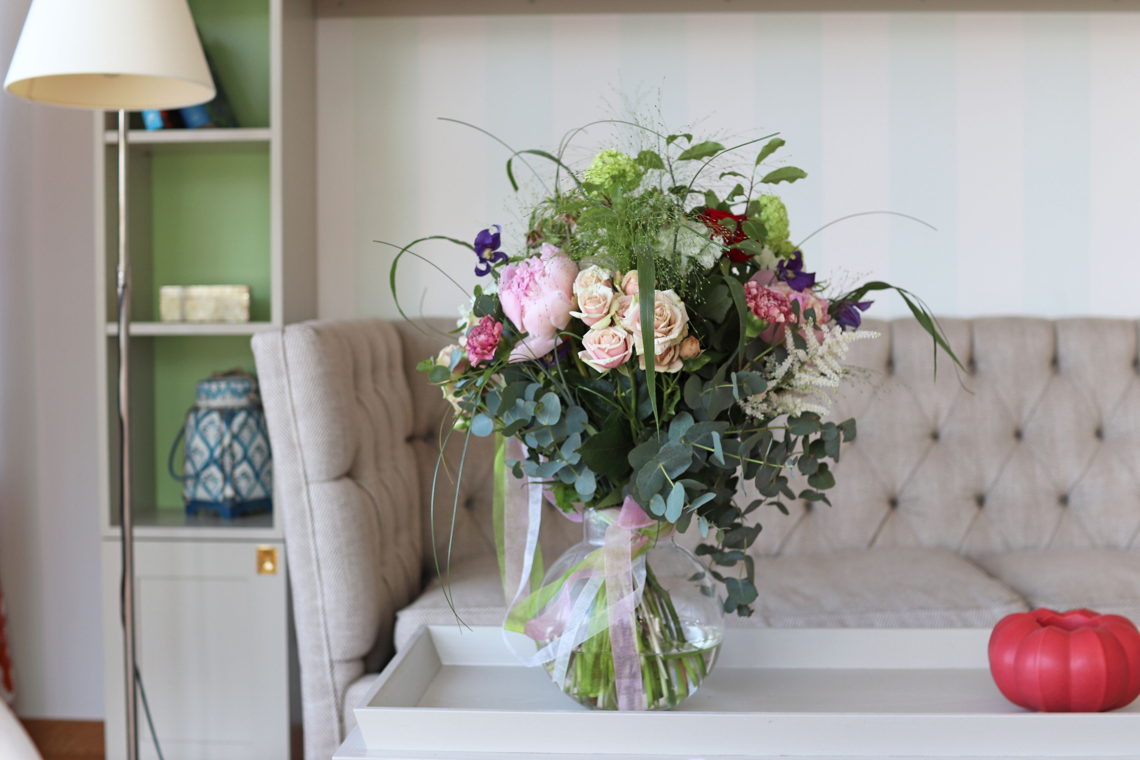 A vase with a floral arrangement on a white tray.