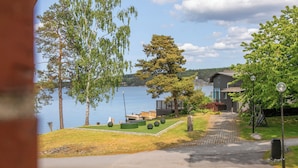 Una propiedad junto al lago con un sendero pavimentado, un banco de madera y vistas al lago.