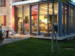 A restaurant with outdoor seating, large windows, and a stone facade. - Hôtel au Boeuf Rouge (Crassier)