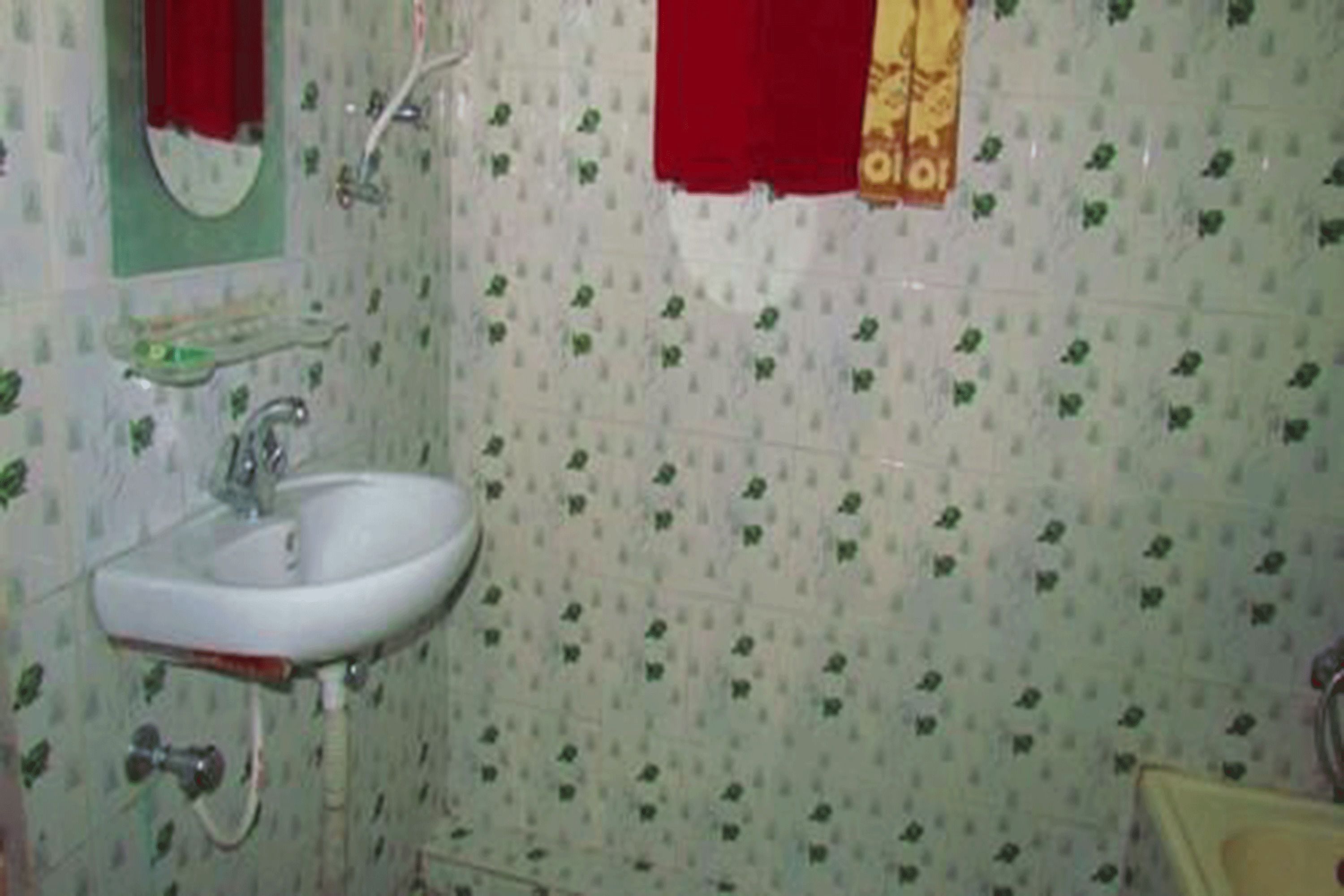 A bathroom with a white sink, a mirror, and a shower.