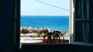 A view from a balcony overlooking a coastal area with buildings and the sea. - Galini Bungalows (Tinos)